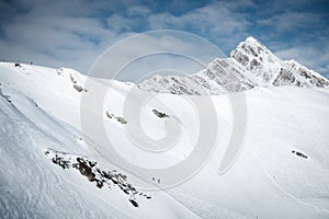 Ski resort in winter Alps. Skiers ride down the slope. Tux, Hintertux, Austria