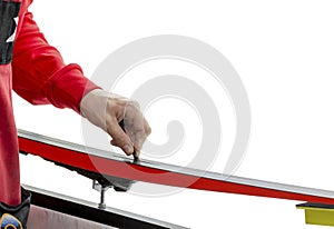Ski service. Serviceman applies repair plastic to a sliding surface on a white background
