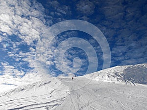 Ski slope on blue sky with clouds.