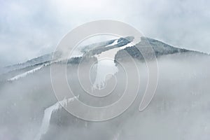 Ski slope mountain in fog, Medvedin resort, Czechia