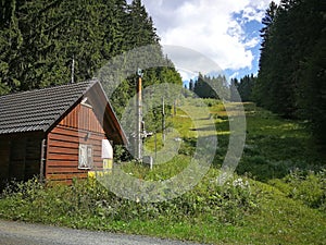 Ski slope overgrown with grass in summer, with ski lift and cottage