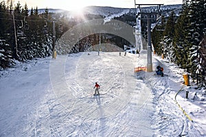 Ski slope, people skiing down the hill, mountains view