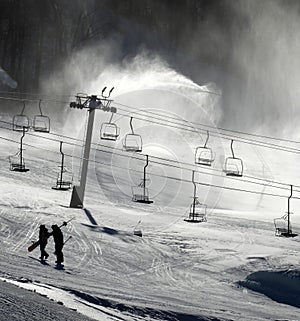 Ski slope silhouette in snow making cloud with chair lifts