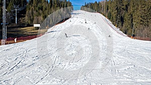 Ski slope with skiers, snowboarders and chairlift in Poland