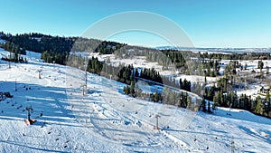 Ski slope with skiers, snowboarders and chairlifts in Poland