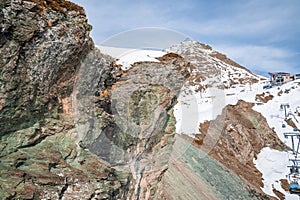 Ski lift station on majestic rocky mountain range against sky in alps
