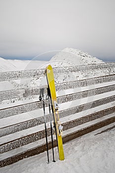 Ski stick in snow mountains on background