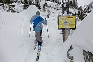 Ski-tour guide leads the group in an avalanche-dangerous backcountry area in snowy High Tatras, Slovakia