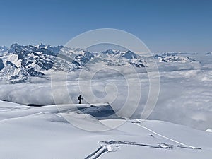 Ski tour in the Swiss mountains. View of the snowy mountains above the clouds. Fantastic views and a powder run. Glarus