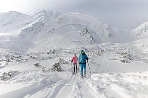 Ski touring couple hiking up a mountain in the Low Tatras in Slovakia.