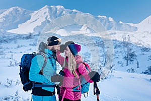 Ski touring couple in love taking break on the top of mountain in the Low Tatras in Slovakia.