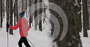 Ski touring in deep fresh snow - young couple skiing in snowy winter forest