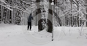 Ski touring in deep fresh snow - young couple skiing in snowy winter forest