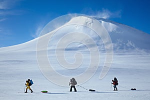 Ski touring group with backpacks and sleds pulkas