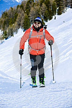Ski touring man reaching the top at sunrise.