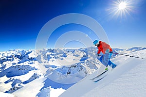 Ski touring man reaching the top in Swiss Alps.