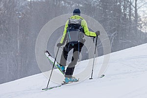 Ski touring, a person is performing a 45 degree turn while walking uphill with skis, modern equipment for ski touring, snow is