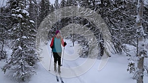 Ski touring - woman with skis in snowy winter forest. Finland