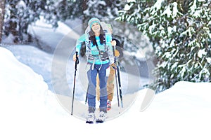 Ski touring in the woods during snowfall. A happy girl