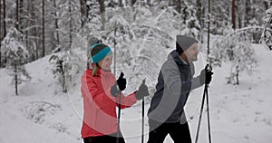 Ski touring - young couple skiing in snowy winter forest