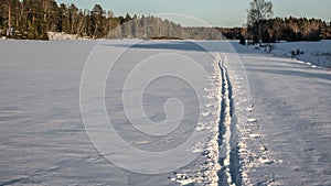 Ski trail on a field. Traces of skis and rods