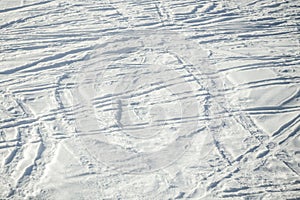 Ski trails and tracks texture in fresh snow. Sunny day. Background with copy space for text.