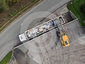 Skid steer loader loading a truck with waste material, aerial view photo