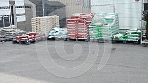 skids palettes of packaged garden soil in parking lot on display for sale..