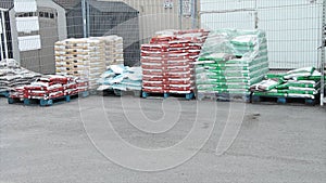 skids palettes of packaged garden soil in parking lot on display for sale..