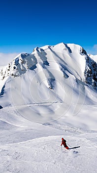 A skier alone on the ski slopes with blue sky