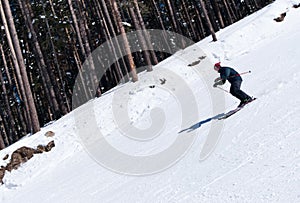 Skier carving down from steep slope