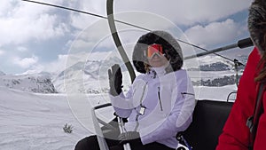 Skier Climbs Up The Chair Lift To The Mountain Top And Wave Her Hand In Greeting