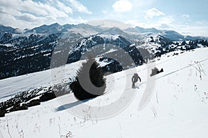 Skier descends through the snow against the backdrop of the mountains