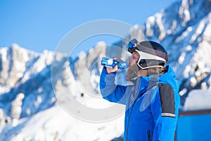 Skier drink water in mountains photo