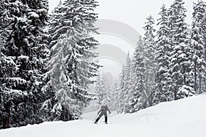 Skier on an empty ski road in the french alps, snowing