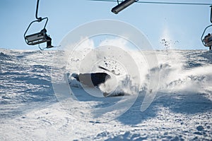 Skier falling with fresh snow powder on the slope