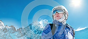Skier female portrait in safe ski helmet and goggles with picturesque snowy Tatry mountains background. Active people winer
