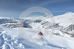 Skier is freeriding against the background of the peaks of Mount Ushba, the Great Caucasian Range in winter