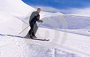 Skier going down on slope