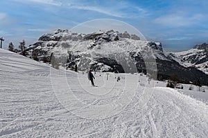 Skier having Fun on a Snowy Ski Slope in the Italian Dolomites Mountains and Chair Lift  in the distance