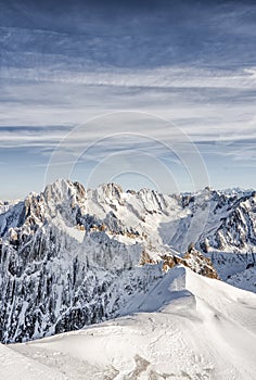 Skier hiker slowy walk down on a massive snow mountain slope on top of alps mont blanc