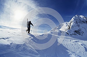 Skier Hiking To Mountain Summit