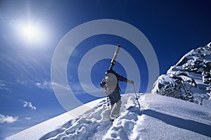 Skier Hiking To Mountain Summit