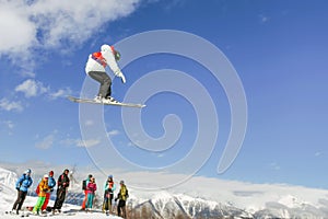 Skier instructor doing high jump above the mountain