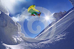 Skier jumping against blue sky from the rock