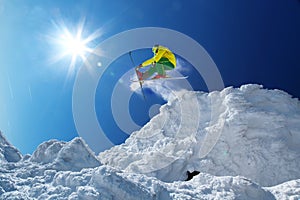 Skier jumping against blue sky from the rock