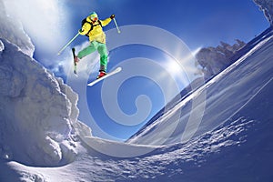 Skier jumping against blue sky from the rock