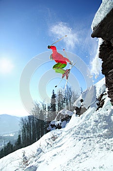 Skier jumping against blue sky from the rock