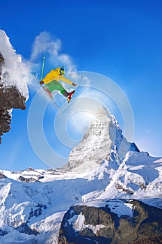 Skier jumping against Matterhorn peak in Switzerland.