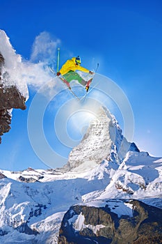 Skier jumping against Matterhorn peak in Switzerland.